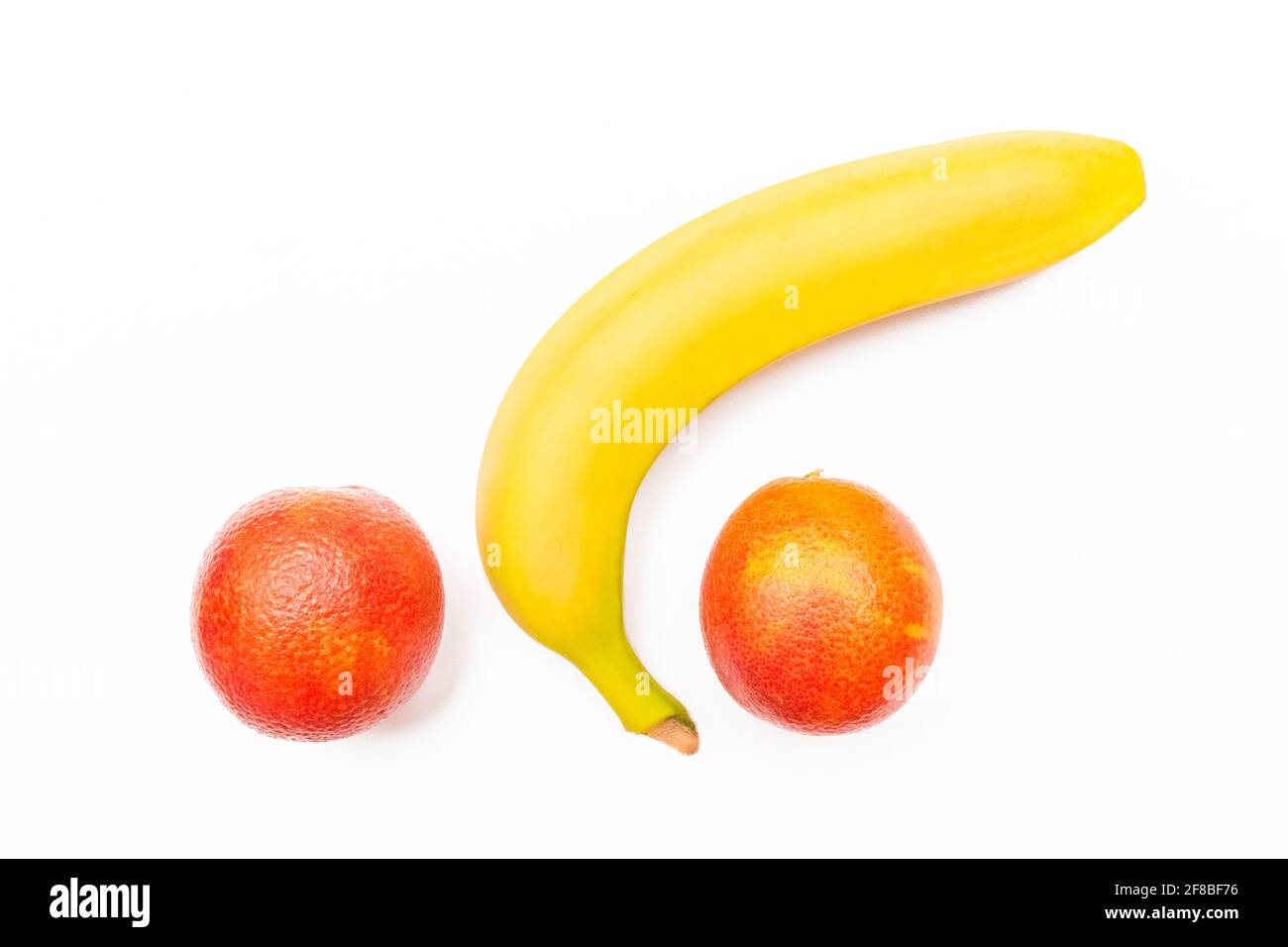 Drôle de concept de fruit, banane et deux oranges rouges isolées sur fond blanc. Banque D'Images Drôle de concept de fruit, banane et deux oranges rouges isolées sur fond blanc. Banque D'Images