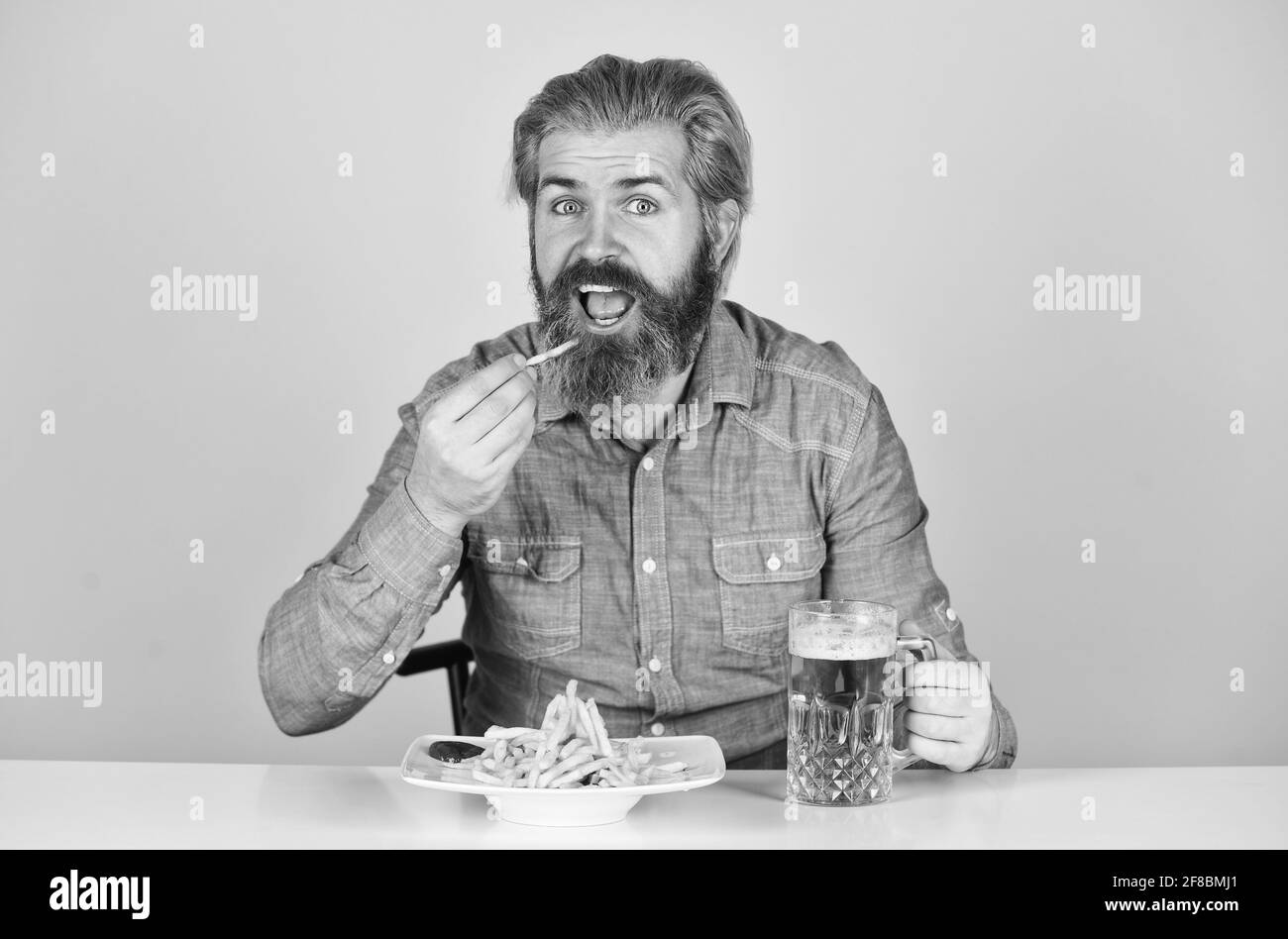 Bar restaurant. Joyeux homme barbu hipster bière. Concept de fête du vendredi. Bon appétit. Consommez de l'alcool. Profitez de votre repas. Bière et nourriture Banque D'Images