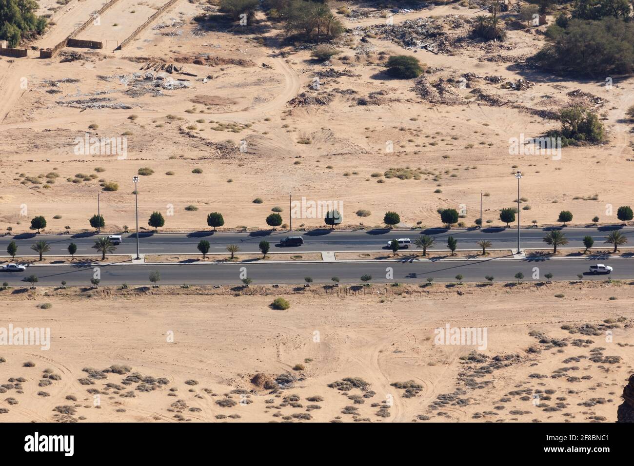 Route typique en Arabie Saoudite qui mène à travers un village dans le désert Banque D'Images