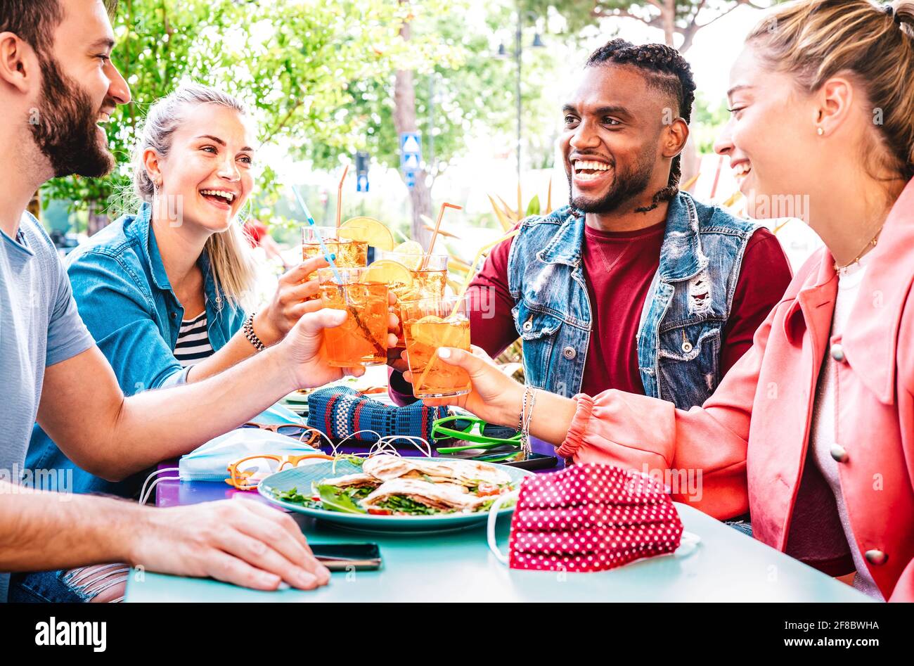 Des amis se frapune au bar-restaurant en plein air - Concept de style de vie avec les jeunes s'amusant ensemble partage boissons à l'happy hour Banque D'Images