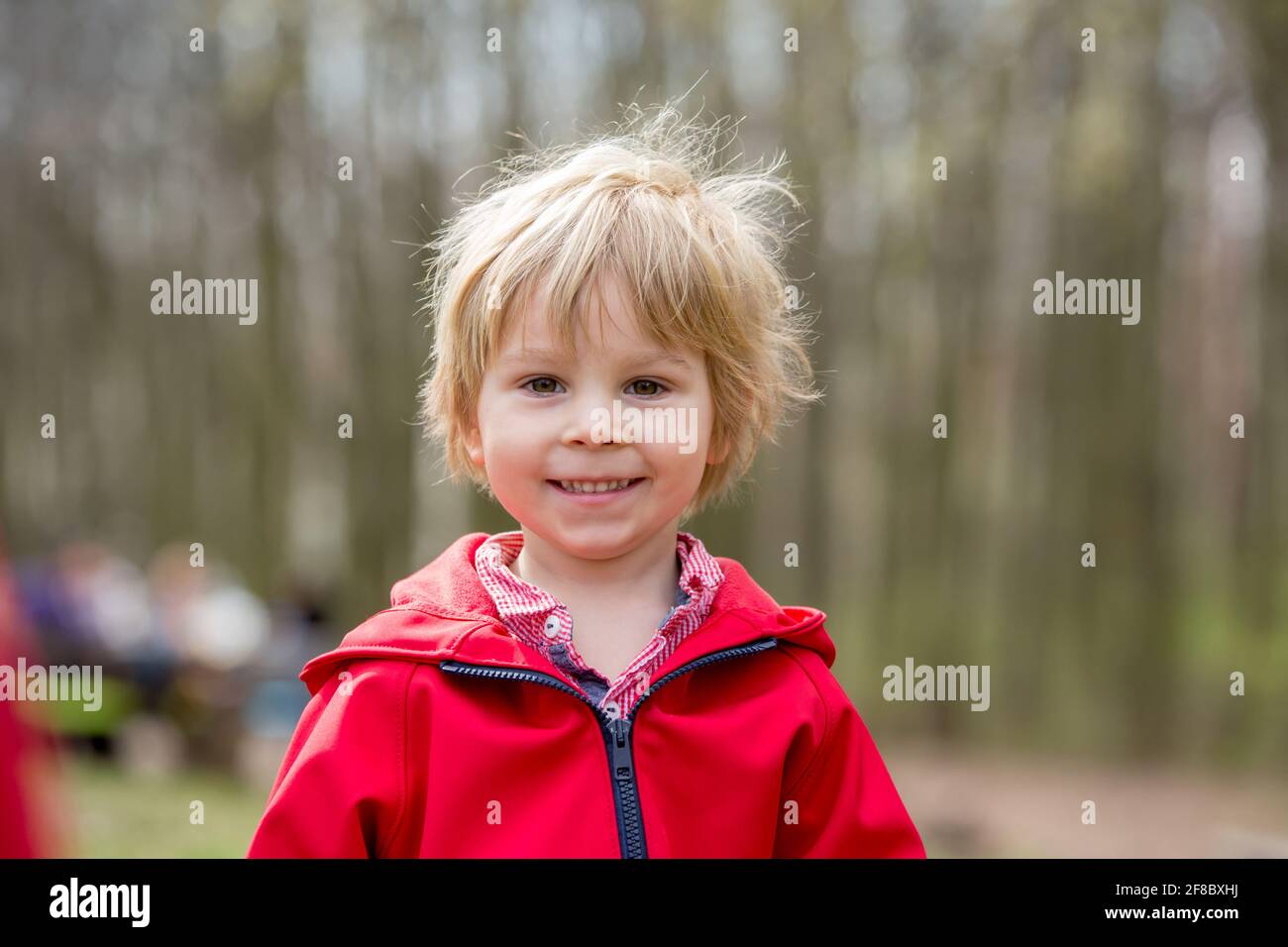 Gros portrait d'un enfant blond souriant, mignon garçon avec une veste  rouge dans le parc, printemps Photo Stock - Alamy