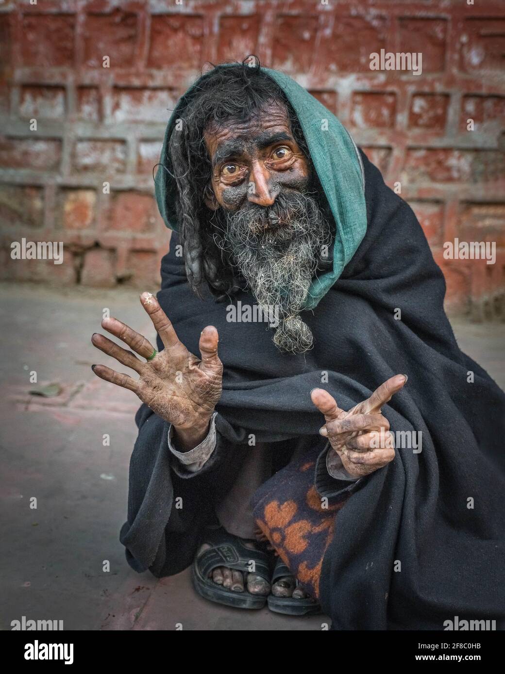 INDE: Un homme portant un capot bleu/vert dans les rues de l'Inde. Des images FASCINANTES ont capturé les personnages bizarres et colorés de l'Inde - y compris Banque D'Images