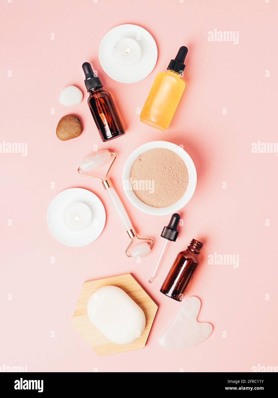 Composition spa sur fond rose pastel. Cosmétiques naturels bio bouteille d'huile, crème, argile, sel, outil de massage gua sha accessoires plan Banque D'Images