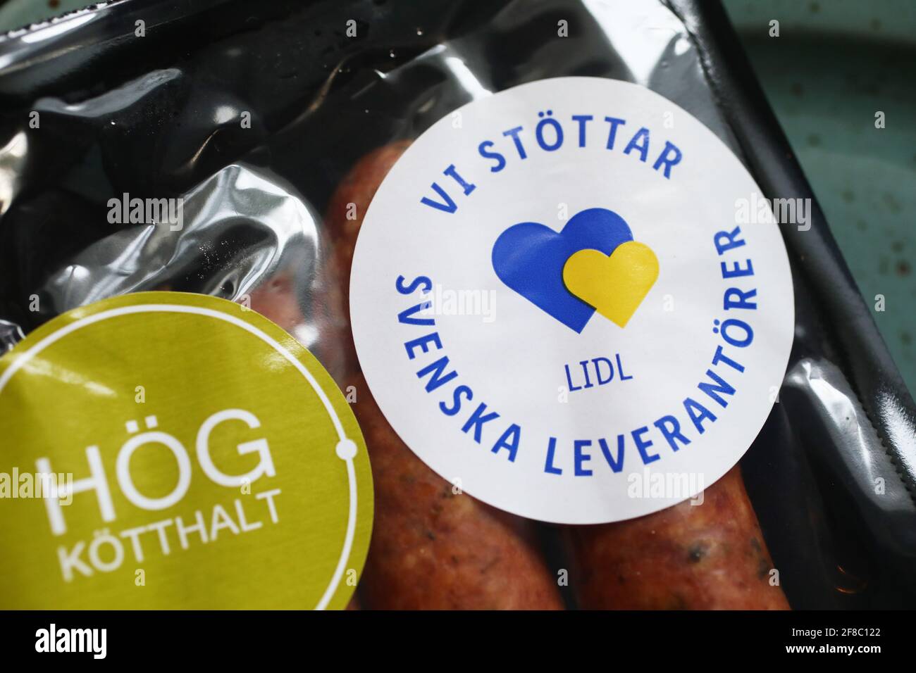 Saucisses de Lidl. Texte indiquant que Lidl prend en charge les fournisseurs suédois. Banque D'Images