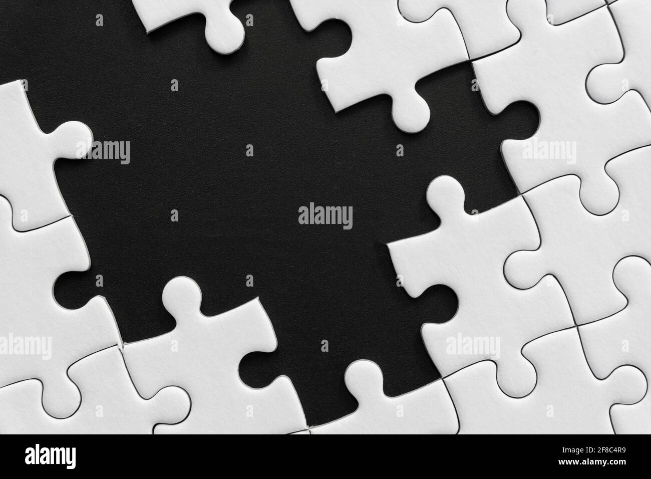 Puzzle blanc inachevé sur fond noir Banque D'Images