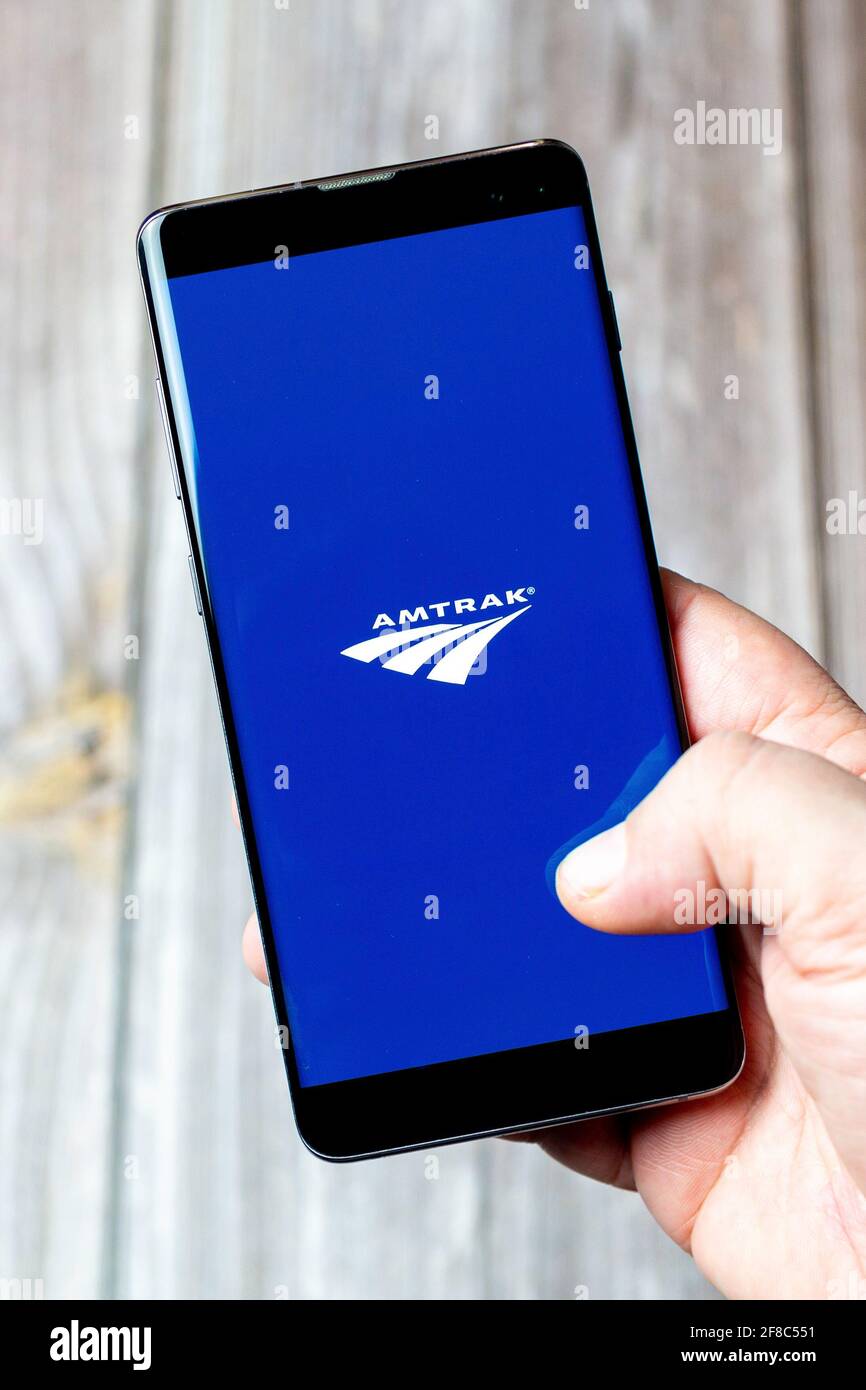 Un téléphone mobile ou mobile tenu dans un Main avec l'application Amtrak ouverte à l'écran Banque D'Images