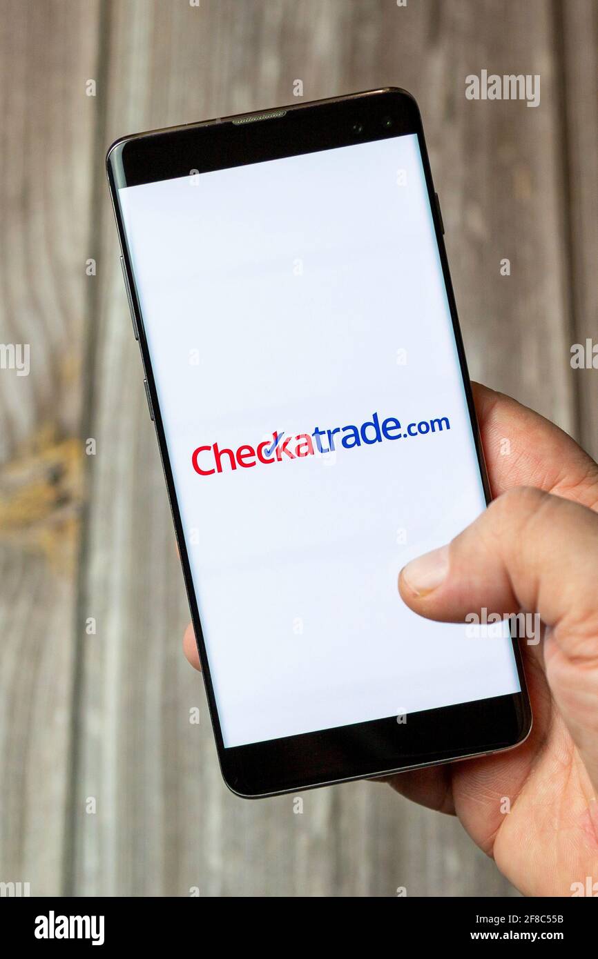 Un téléphone mobile ou mobile tenu dans un Main avec l'application Checkatrade ouverte à l'écran Banque D'Images