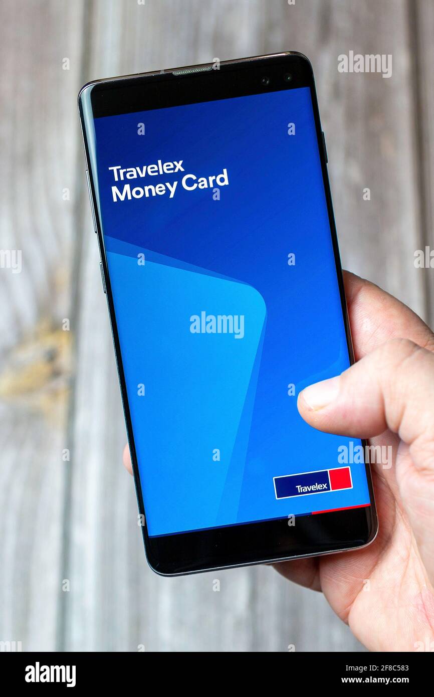 Un téléphone mobile ou mobile tenu dans un Main avec l'application Travelex Money Card ouverte à l'écran Banque D'Images