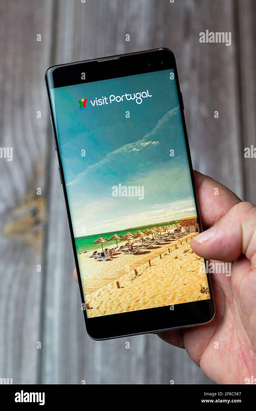 Un téléphone mobile ou mobile tenu dans un Main avec l'application Visit Portugal ouverte à l'écran Banque D'Images
