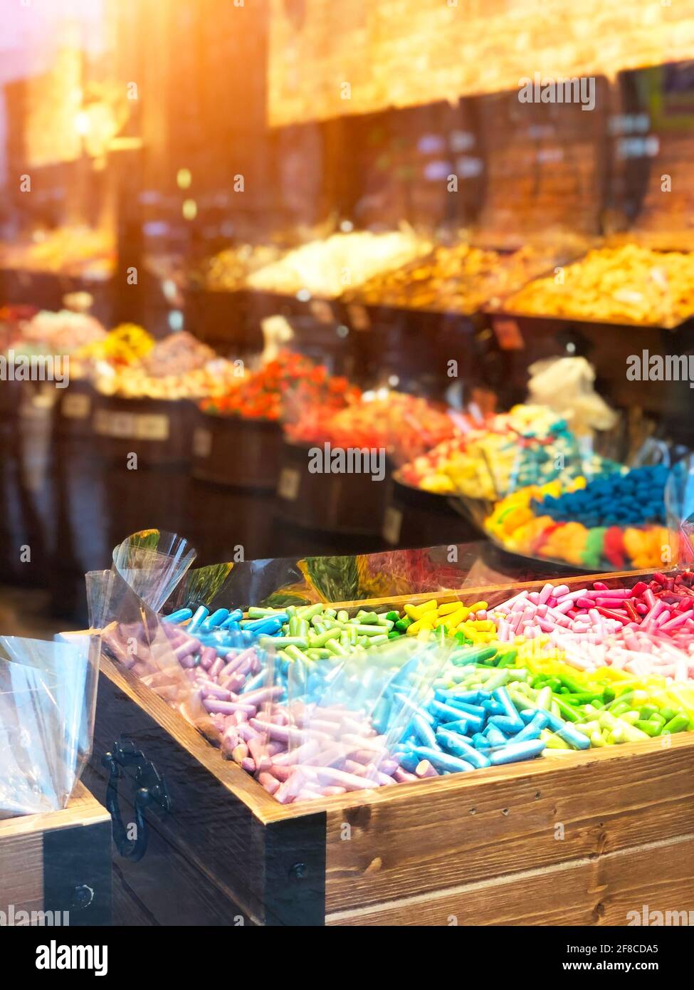 Sucreries sucettes sucreries colorées dans une boîte de poitrine derrière un vitrine en verre Banque D'Images