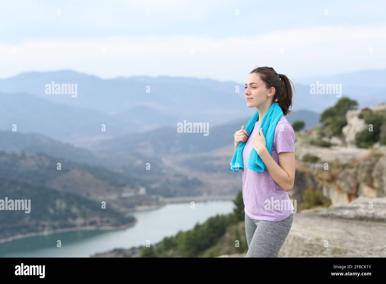 Un bon coureur saisissant une serviette contemplant les vues après le sport dans le montagne Banque D'Images
