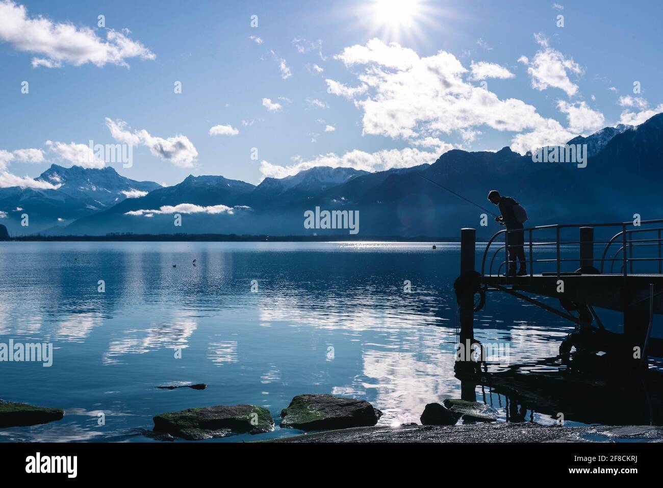 Homme debout sur un quai au bord du lac Léman, Montreux Banque D'Images