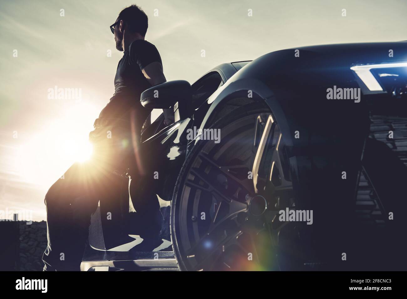 Des hommes qui ont du succès et sa voiture exotique de luxe. Voyage en été et coucher de soleil. Thème automobile Moren. Banque D'Images