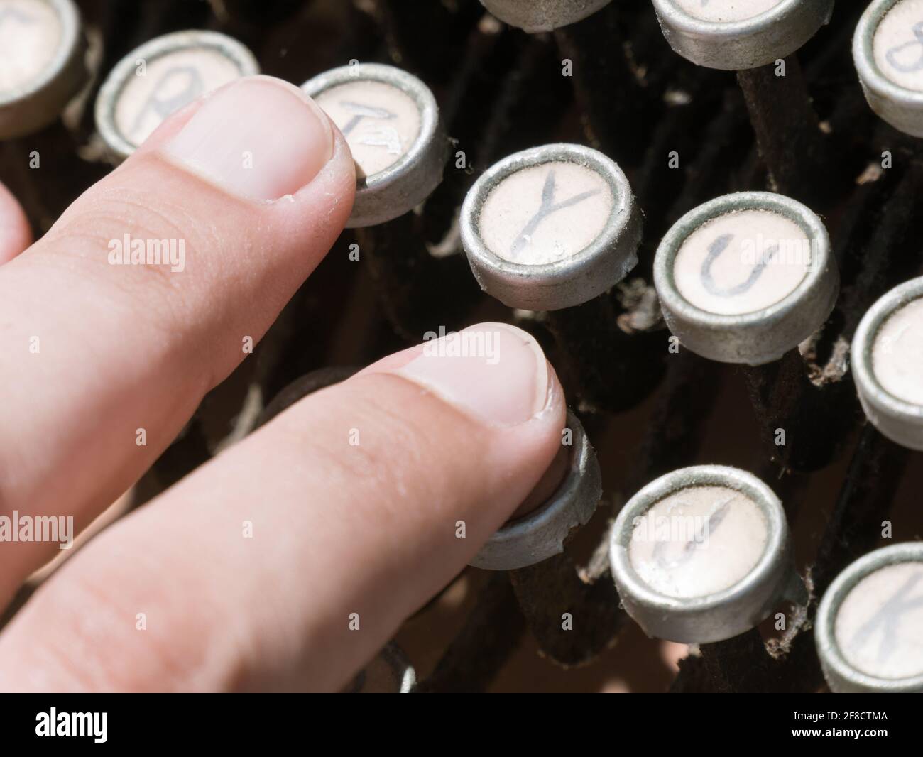 Cliché sélectif de doigts sur une machine à écrire ancienne Banque D'Images