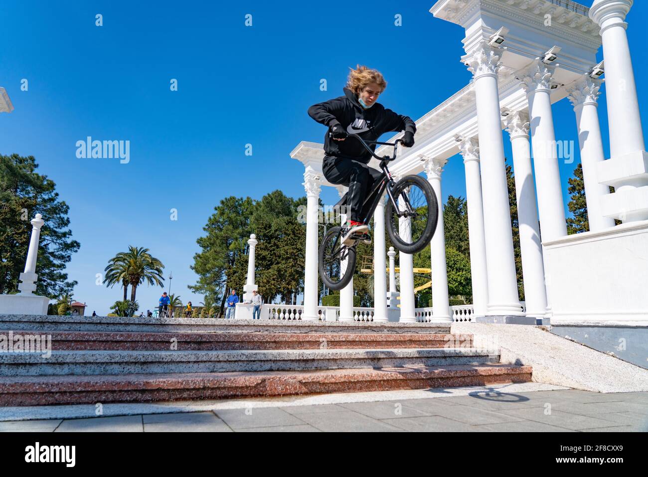 Batumi, Géorgie - 8 avril 2021 : un adolescent sautant des escaliers sur un vélo Banque D'Images