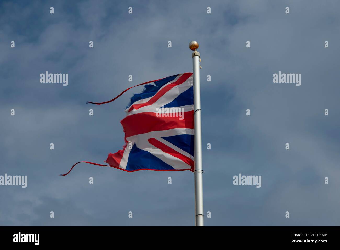 Drapeau de l'Union Jack déchiré en moitié par le vent, le brexit et le concept de décentralisation. Banque D'Images