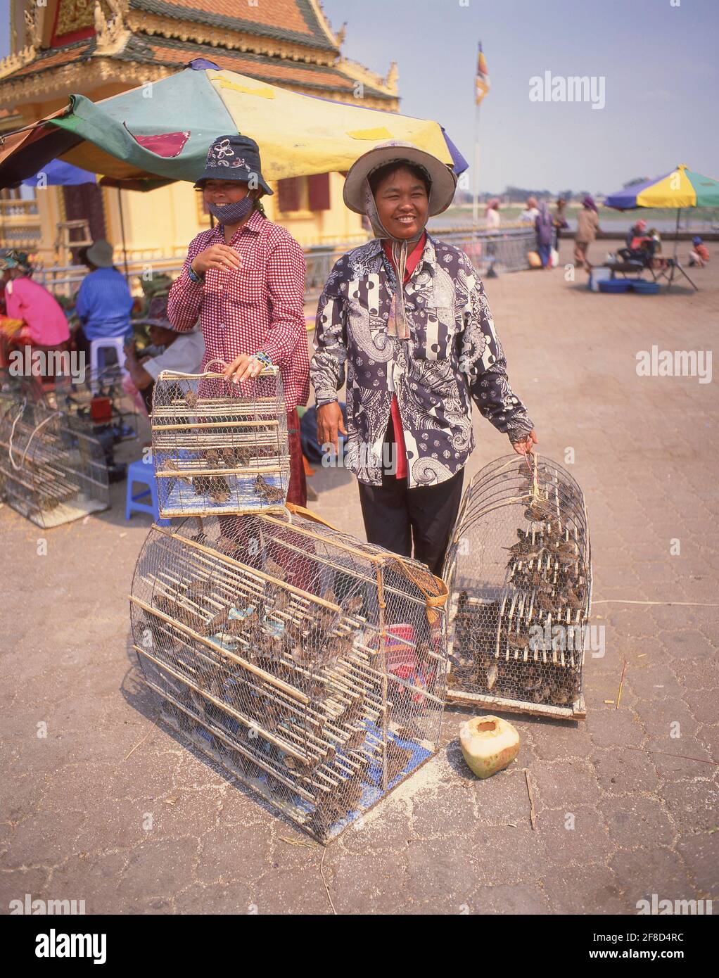 Couple avec cages d'oiseaux (payer pour libérer un oiseau) dans le centre ville de Phnom Penh, Royaume du Cambodge Banque D'Images