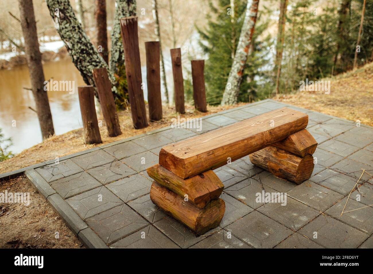 banc en bois sur la rive de la rivière. un endroit calme et isolé dans un parc déserté dans le bosom de la nature. un endroit pour se détendre au début du printemps dans un parc forestier Banque D'Images