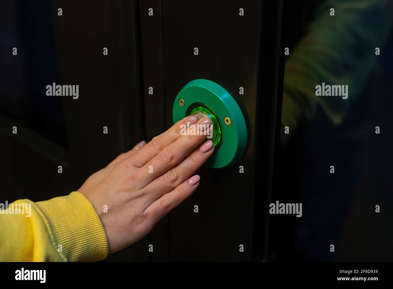 Bouton d'ouverture des portes du train. Gros plan des mains des femmes sur  le bouton vert de l'ouvre-porte automatique Photo Stock - Alamy