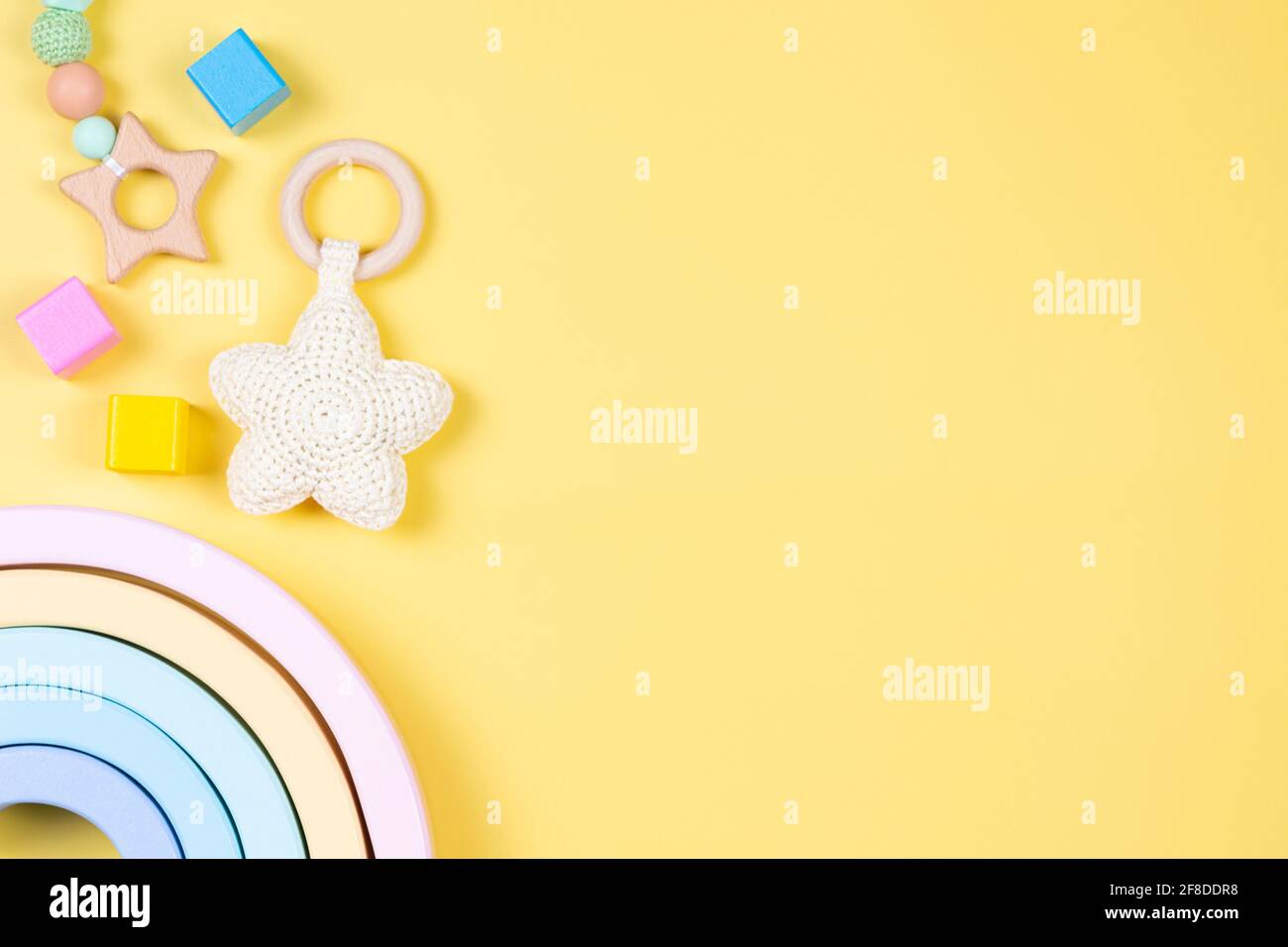 Jouets pour enfants sur fond jaune. Développement durable de la petite enfance produits pour bébés et jouets en bois de couleur pastel naturelle. Vue de dessus, plan d'appartement. Banque D'Images