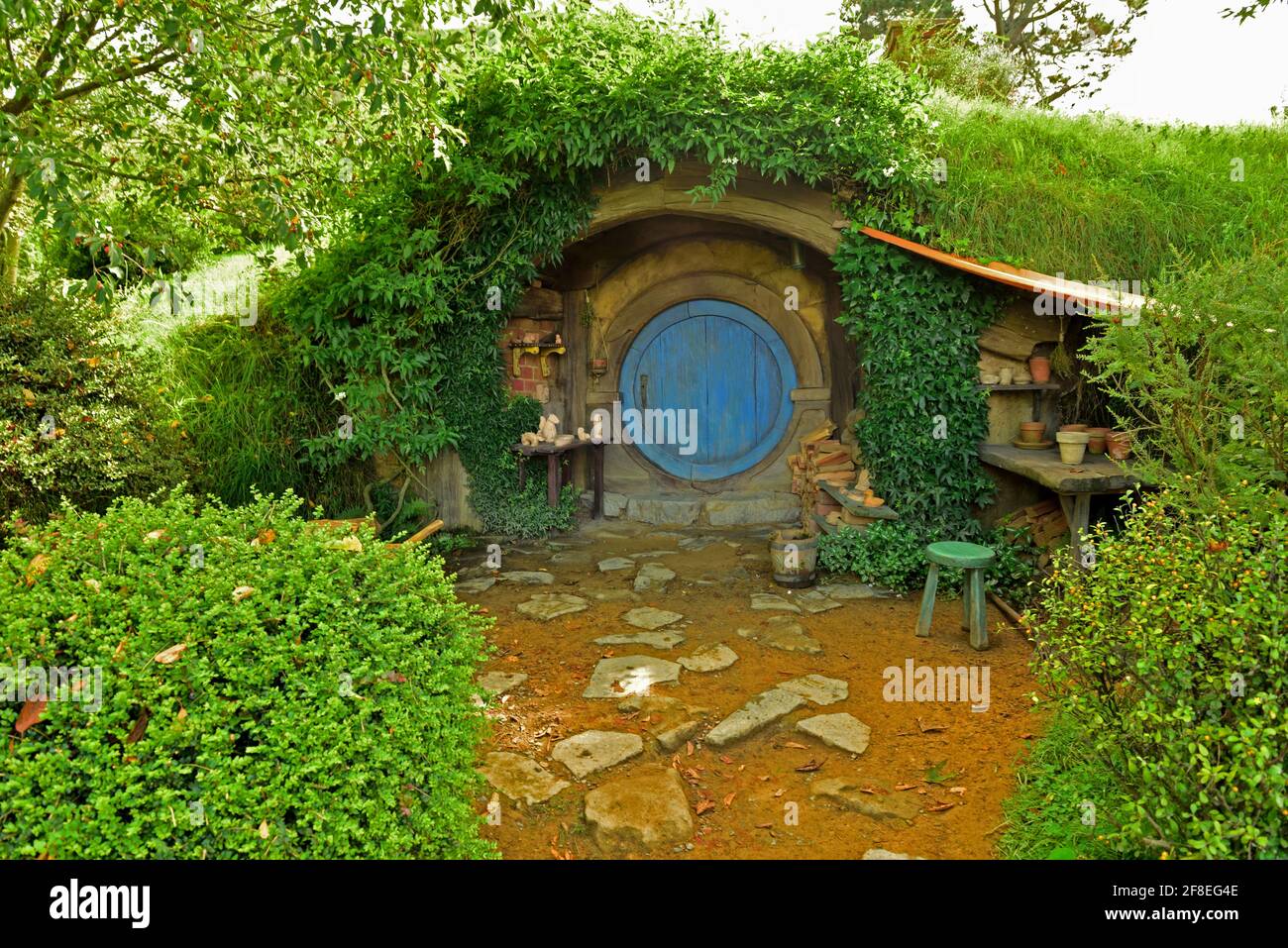 Au cœur de la campagne de Hamilton & Waikato, discrètement cachée derrière des collines verdoyantes, se trouve un lieu unique : le décor Hobbiton Movie Set ; le Per Banque D'Images