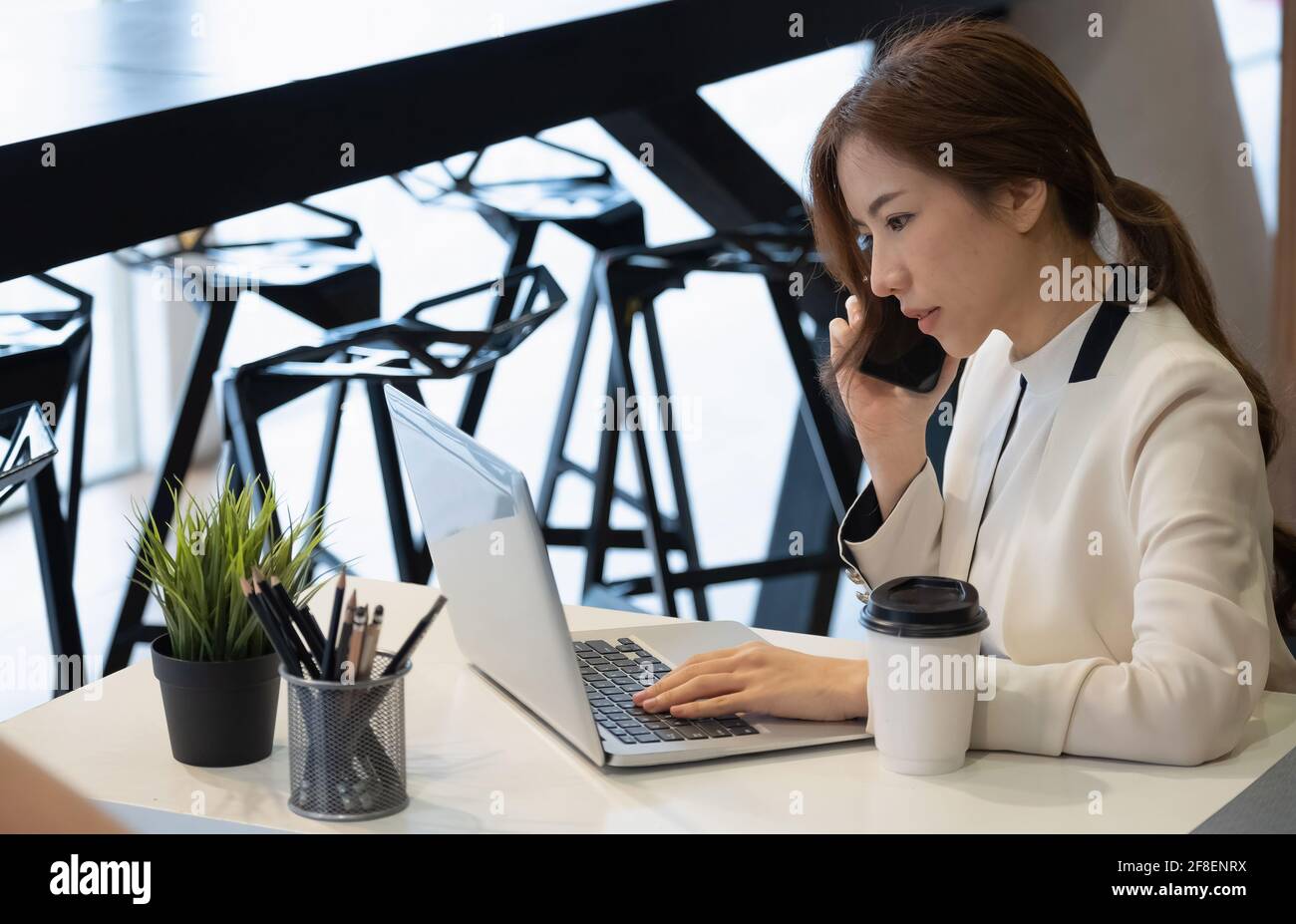 Photo d'une femme d'affaires asiatique travaillant en tant que gestionnaire de contenu avec ses clients par smartphone Banque D'Images
