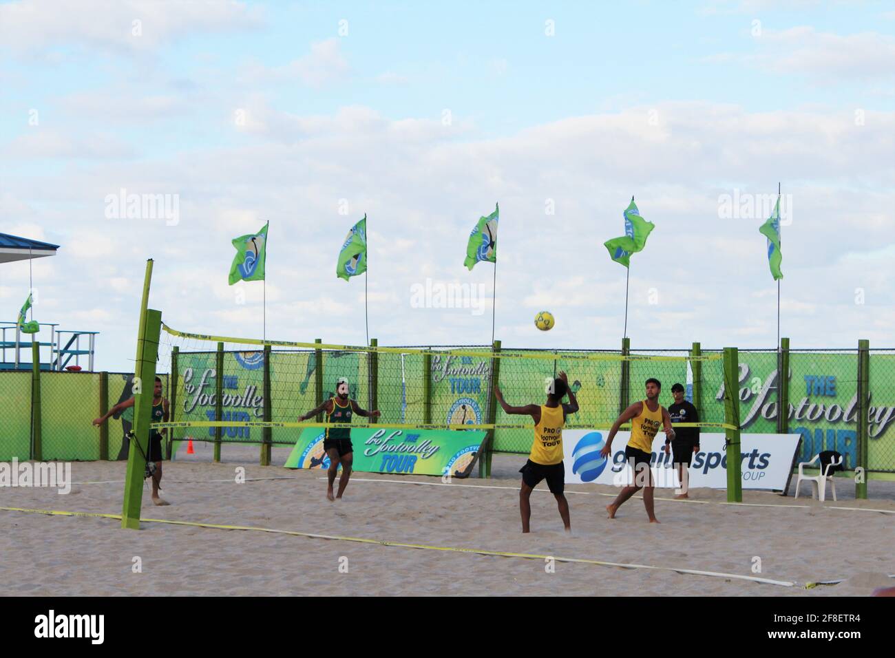 Groupe de personnes jouant à un jeu appelé Footvolley sur le sable de la plage près de l'océan dans le sud de la floride pendant la pandémie COVID-19. Banque D'Images Groupe de personnes jouant à un jeu appelé Footvolley sur le sable de la plage près de l'océan dans le sud de la floride pendant la pandémie COVID-19. Banque D'Images