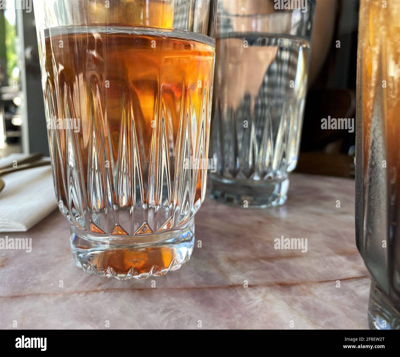 Détails de la tasse en verre avec thé glacé à l'intérieur, apprécié lors d'une chaude journée d'été. Banque D'Images