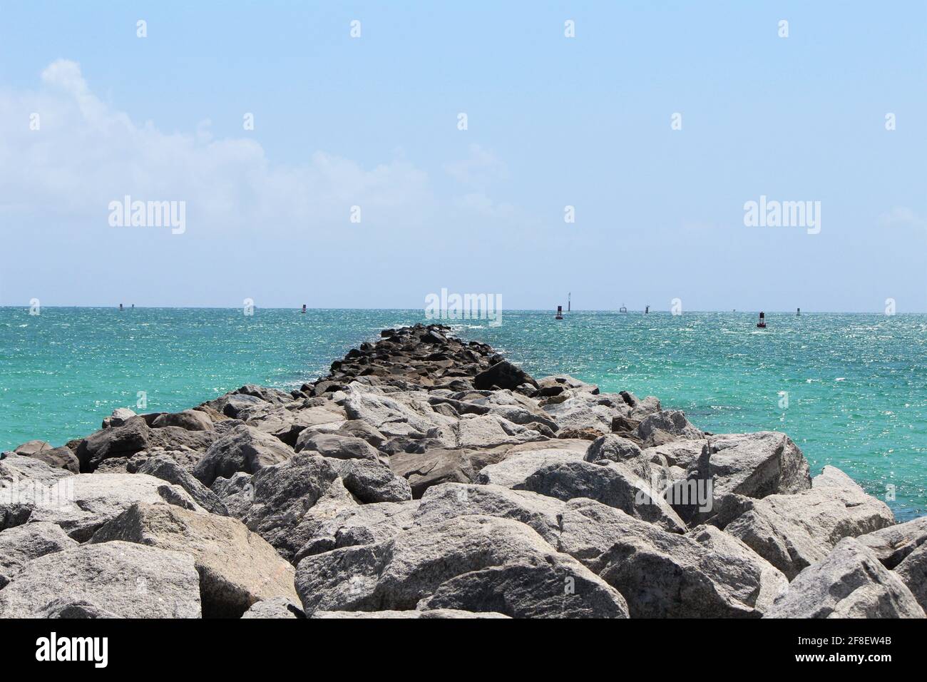 Panorama sur l'océan bleu de la côte sud de la plage, du sud de la floride, reflet du soleil et vagues calmes, pile de rochers dans la mer, sentier rocheux. CopySpace, papier peint Banque D'Images Panorama sur l'océan bleu de la côte sud de la plage, du sud de la floride, reflet du soleil et vagues calmes, pile de rochers dans la mer, sentier rocheux. CopySpace, papier peint Banque D'Images