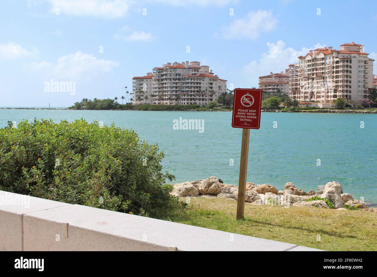 Panneau pour éviter les égouts pluviaux à South Pointe plage de Miami Beach en Floride avec vue sur l'arrière-plan Appartements Palazzo Del sol à Fisher Island Banque D'Images