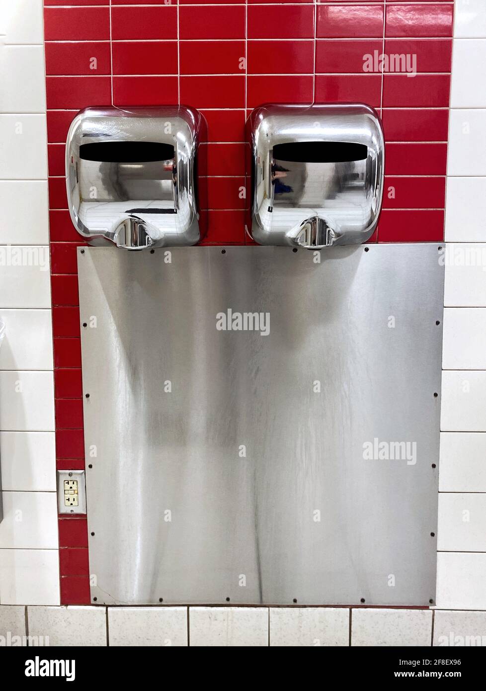 Un sèche-mains moderne est accroché au mur dans une salle de bains publique. Hygiène. Nettoyage des mains. Se laver les mains. Rester à l'abri de la pandémie Covid-19 Banque D'Images