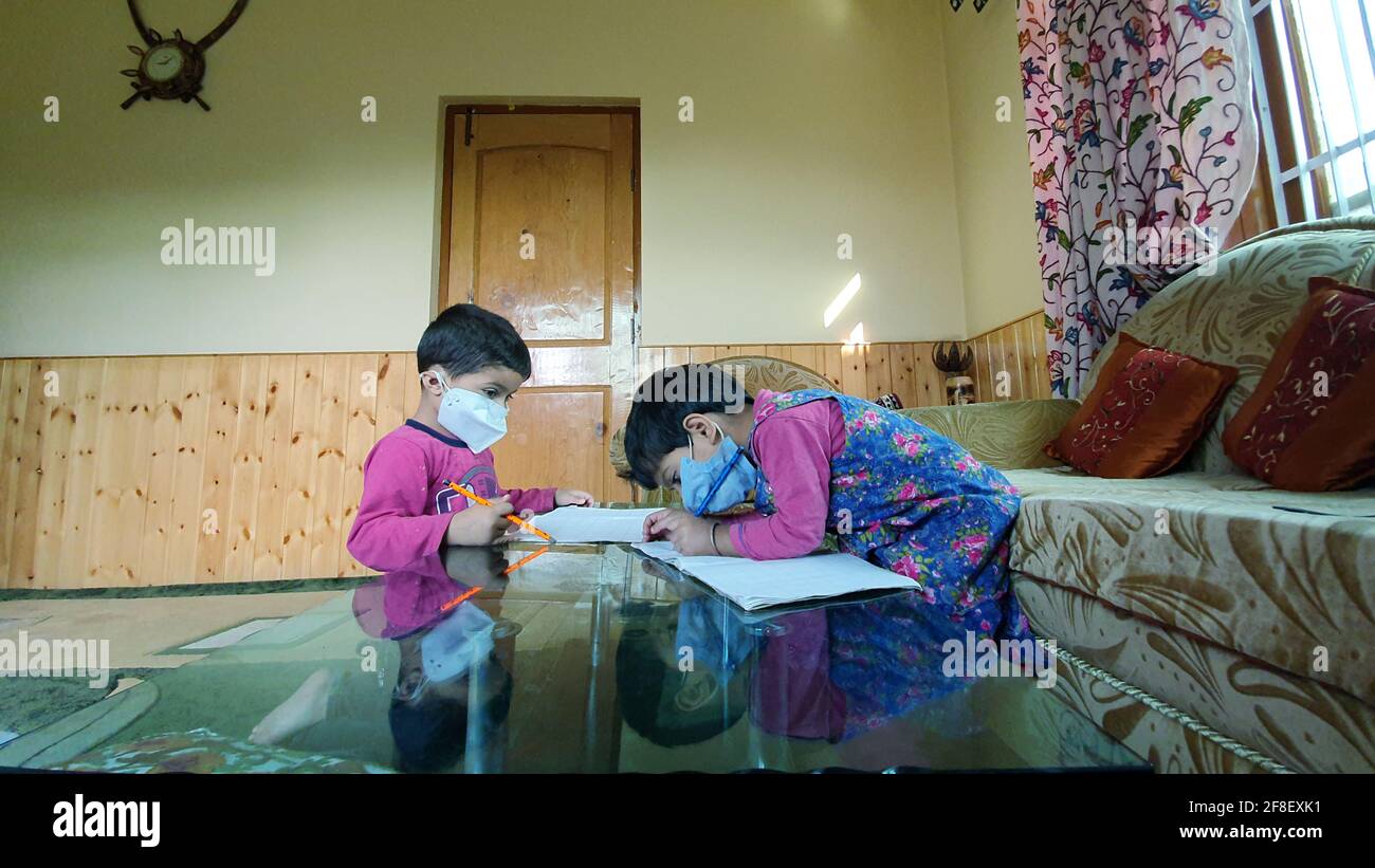 Les élèves de l'école masquée font du travail à domicile à la maison covid-19 Banque D'Images
