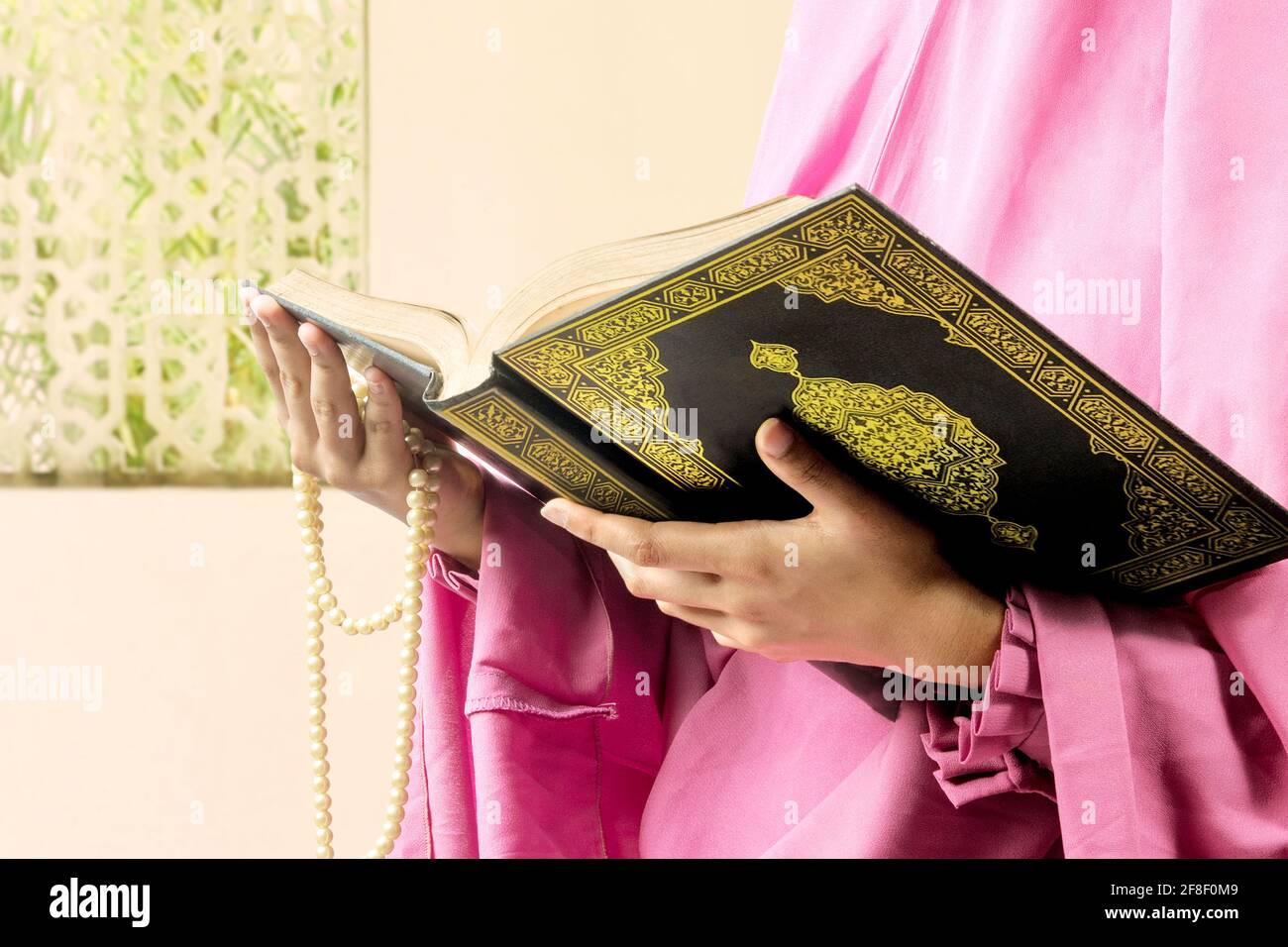 Femme musulmane dans un voile tenant des perles de prière et le Coran sur  la mosquée Photo Stock - Alamy