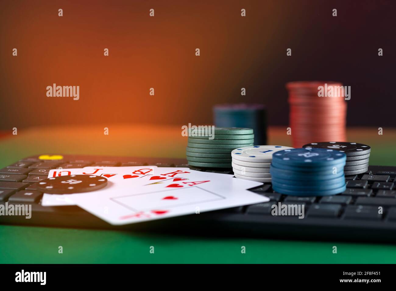 Plate-forme de jeu en ligne, casino et affaires de jeu. Cartes, dés et pièces de jeu multicolores sur le clavier de l'ordinateur portable. Banque D'Images