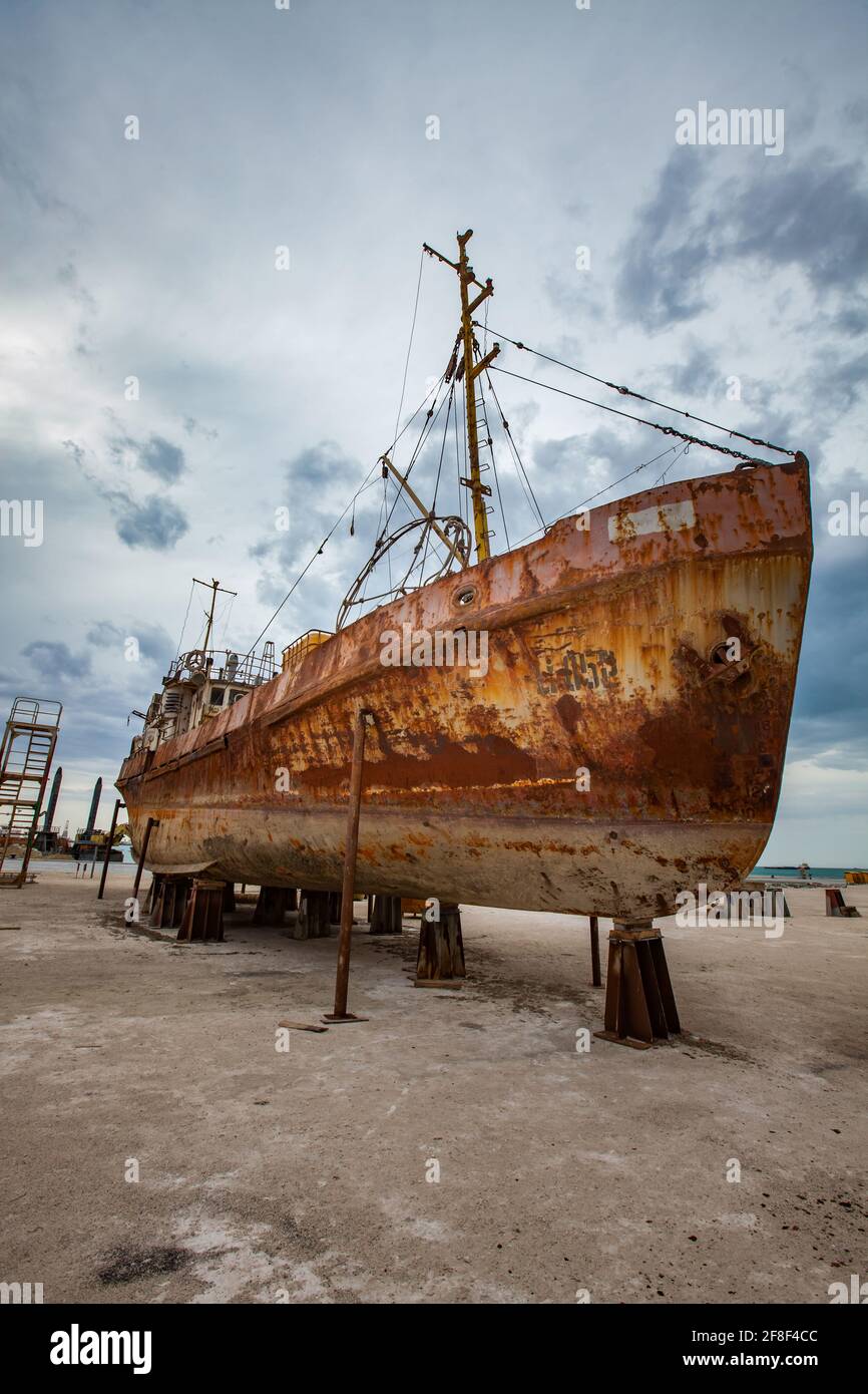 Mangystau, Kazakhstan - 19 mai 2012 : ancien navire en acier rouillé dans une cour de réparation navale. Mer Caspienne, baie de Bautino. Tempête grise ciel nuageux. Banque D'Images