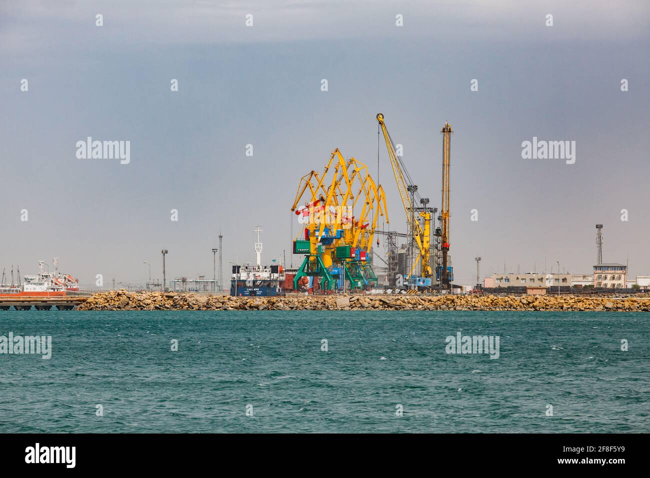 Aktau, Kazakhstan - mai 19 2012 : terminal de chargement de port maritime de fret sur la mer Caspienne. Grues de chargement jaunes. Élévateur de grain en arrière-plan. Ciel gris. Banque D'Images