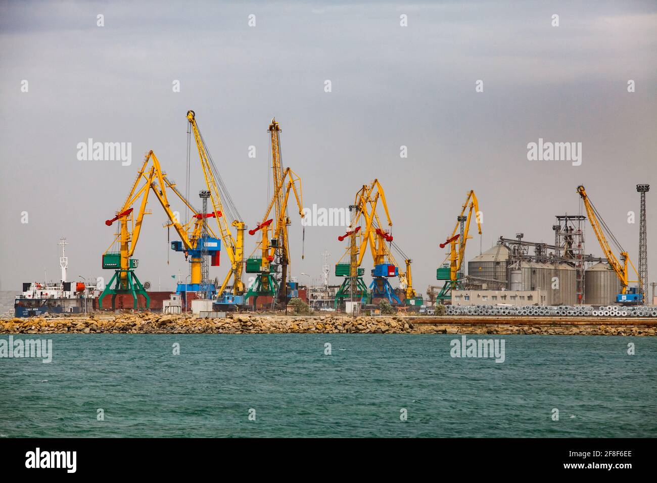 Aktau, Kazakhstan - mai 19 2012 : terminal de chargement de port maritime de fret sur la mer Caspienne. Grues de chargement jaunes. Elévateur de grain droit. Ciel gris Banque D'Images