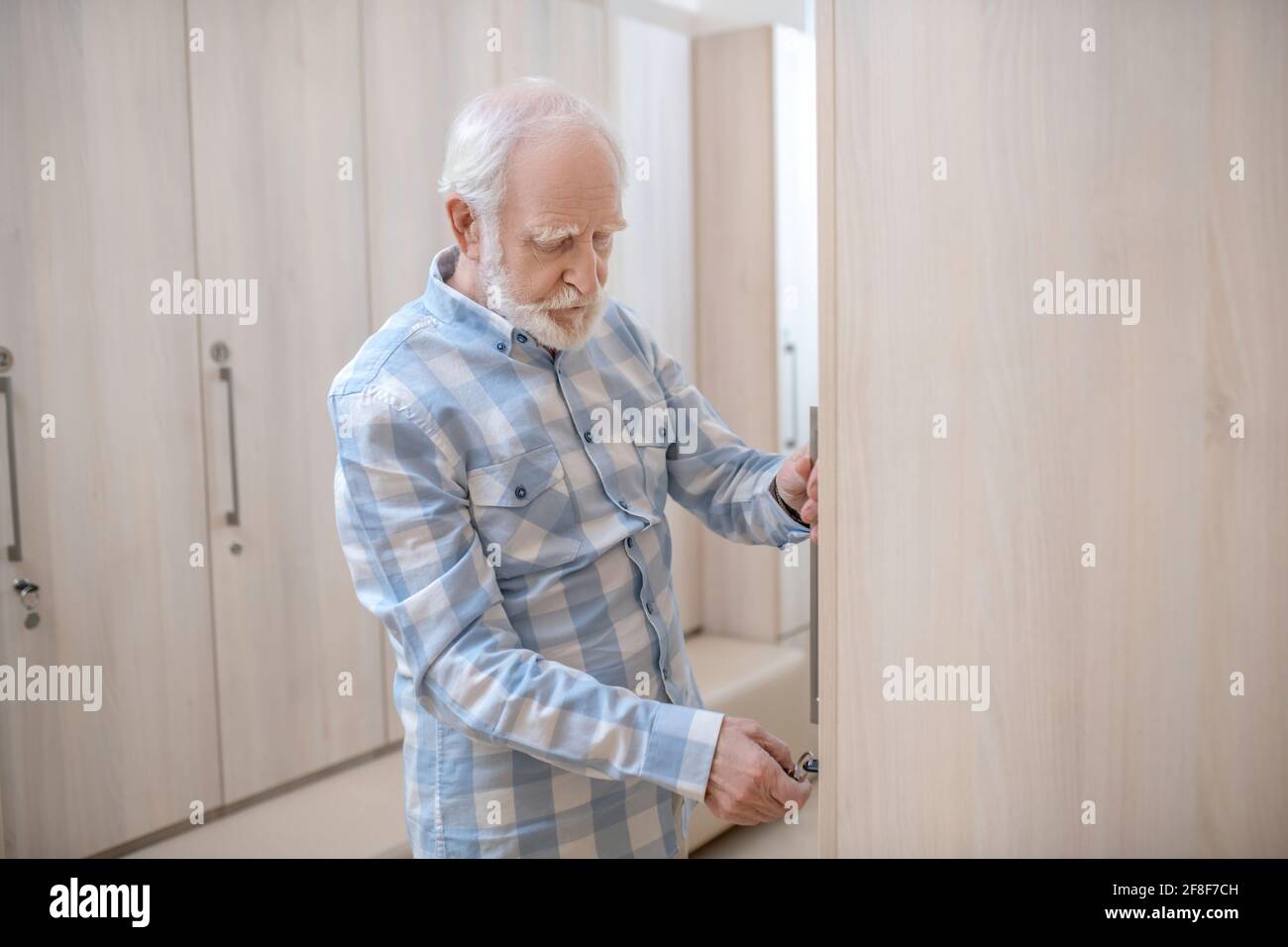 Homme mûr aux cheveux gris dans un vestiaire du centre de spa Banque D'Images