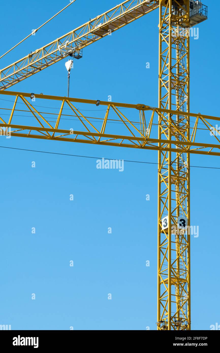 Une grue de construction jaune faite de tuyaux en acier contre un ciel bleu. Banque D'Images