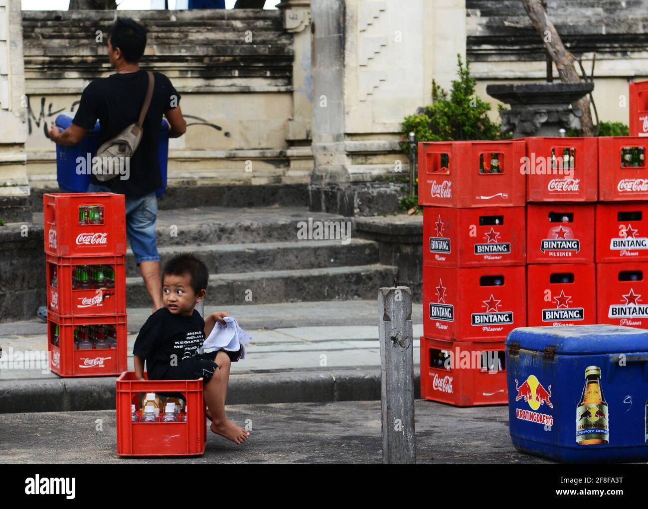 Un jeune balinais assis sur une caisse Coca Cola à Kuta, Bali, Indonésie  Photo Stock - Alamy