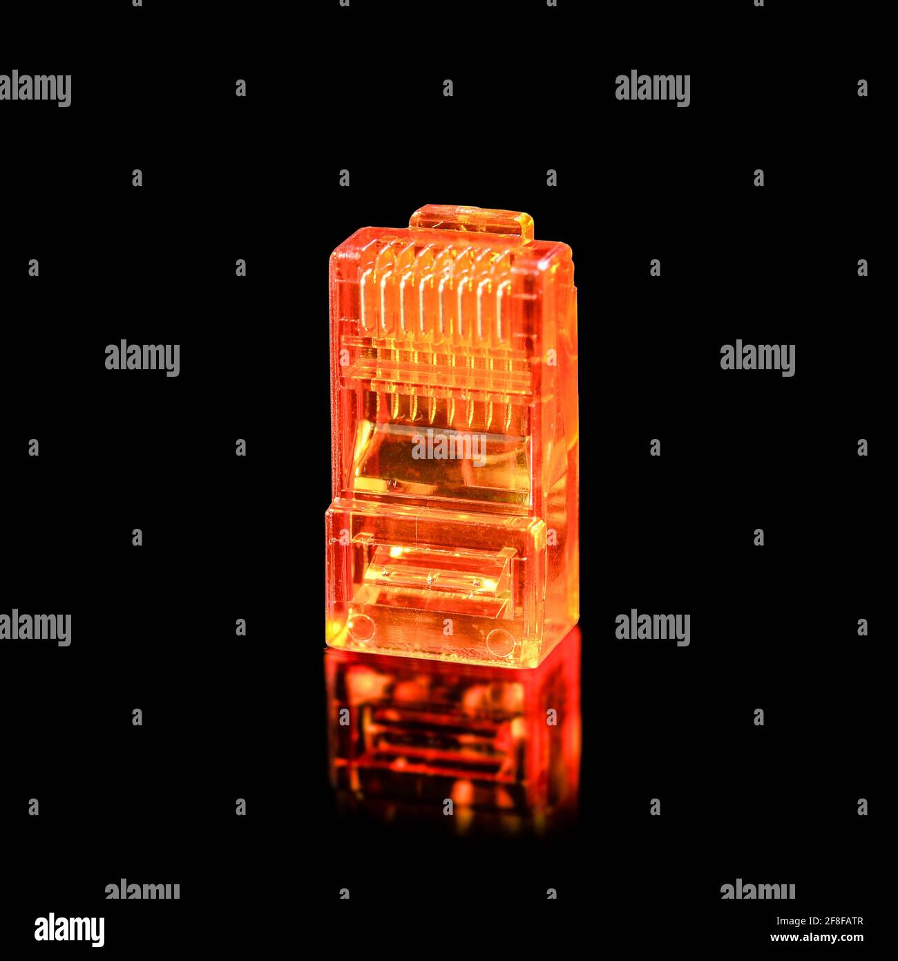 Connecteur rj-45. Connecteur RJ45 transparent orange pour réseau et Internet. Macro de gros plan isolée sur fond noir avec réflexion. Banque D'Images