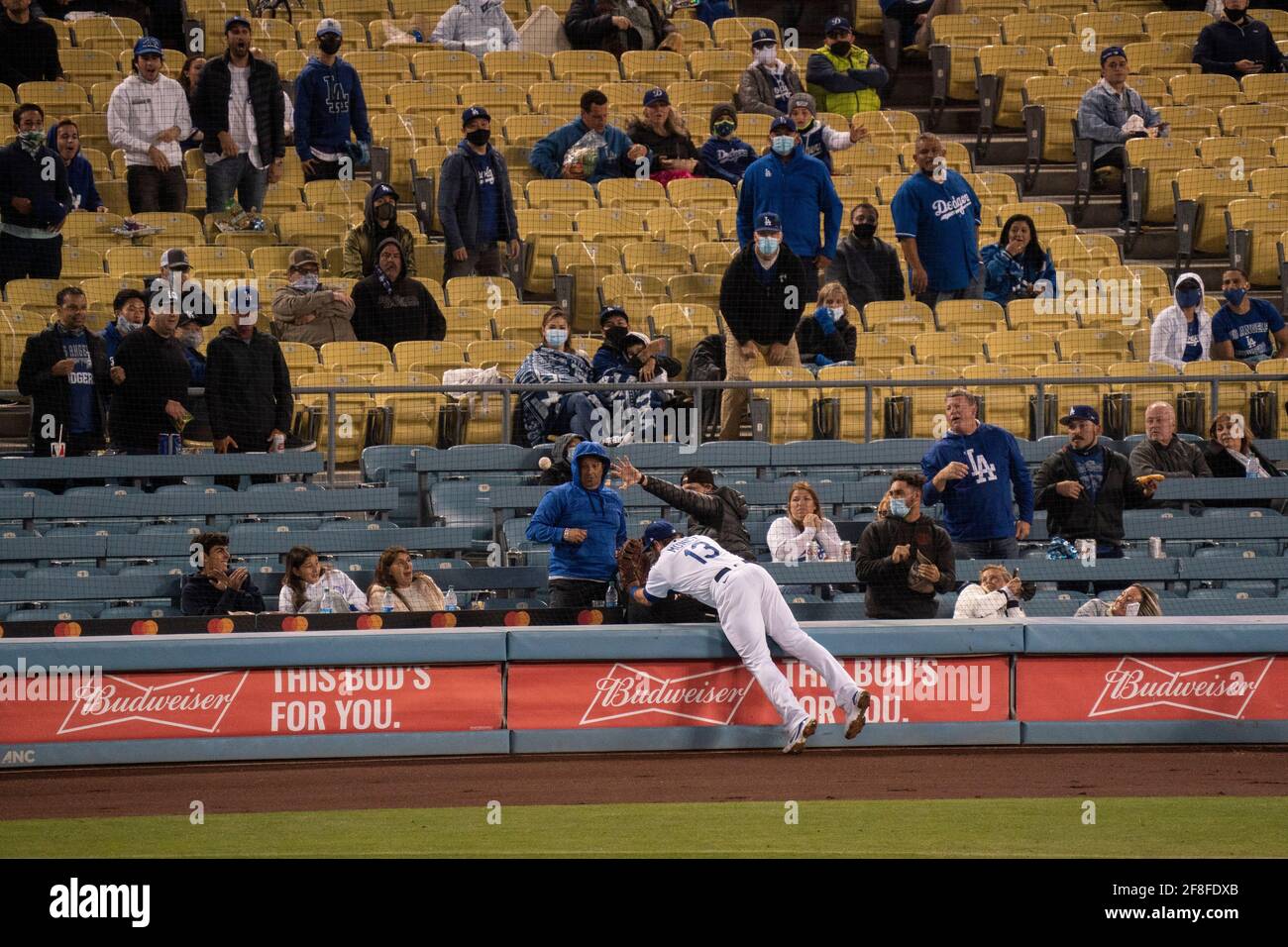 Los Angeles Dodgers premier baseman Max Muncy (13) tombe après avoir tenté de faire une prise lors d'un match MLB contre les Rocheuses du Colorado, mardi, avril Banque D'Images