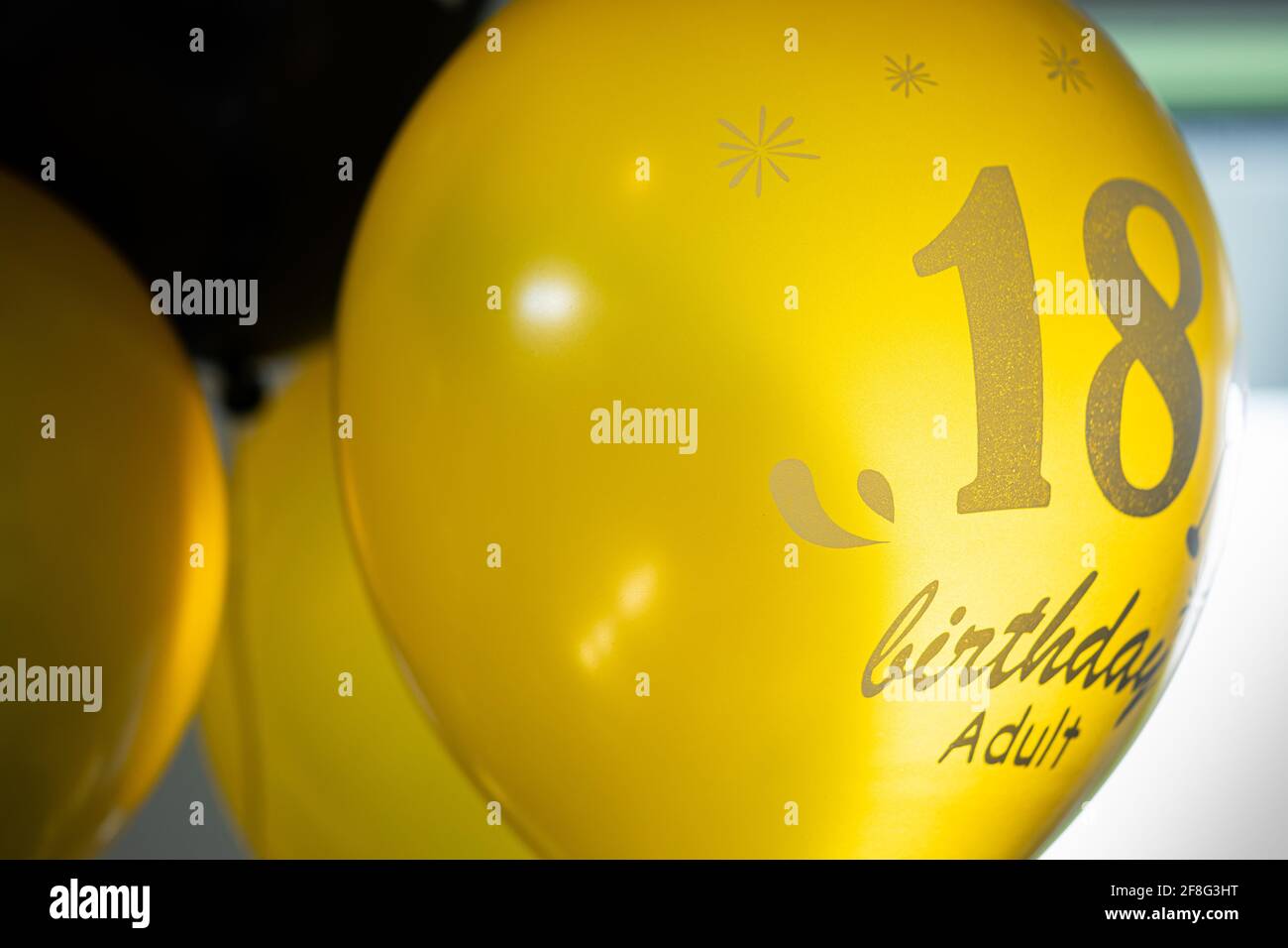 Ballons remplis d'hélium noir et or avec inscription du 18e anniversaire Banque D'Images