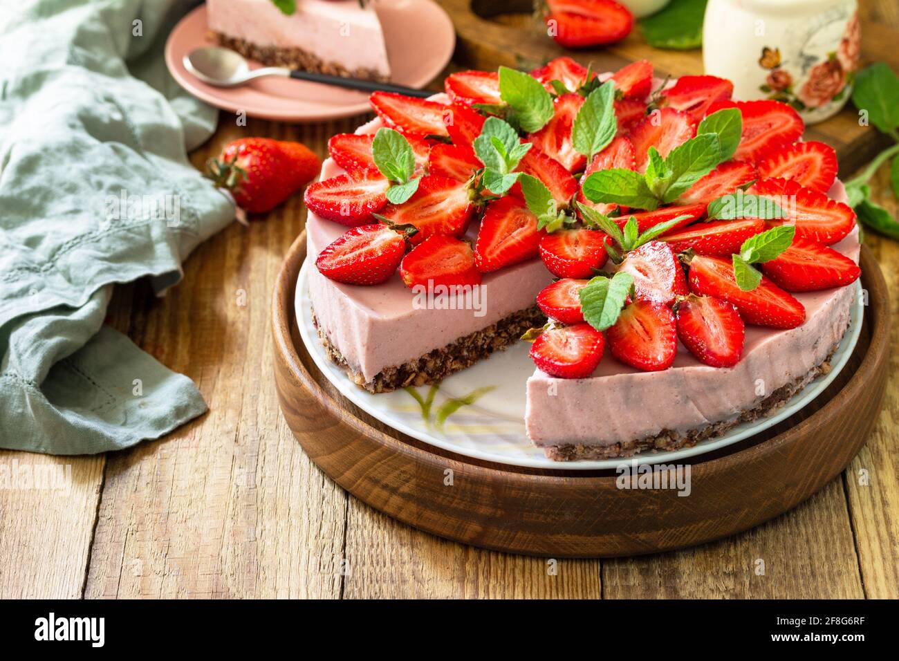 Dessert estival sans cuisson sans gluten, menus d'anniversaire. Cheesecake à la fraise sur une granola avec des fraises fraîches sur une table en bois rustique Banque D'Images