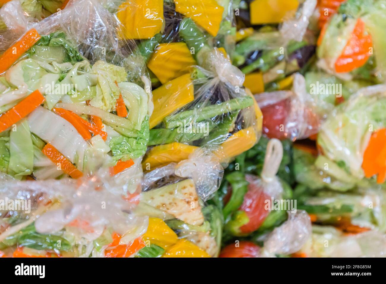 Des paquets colorés de légumes en tranches du marché. Des légumes en morceaux colorés dans des sacs en plastique. Banque D'Images