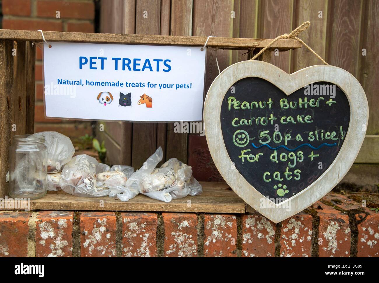 Gâteries maison pour animaux de compagnie faites par un enfant en vente sur le mur du jardin, Royaume-Uni Banque D'Images