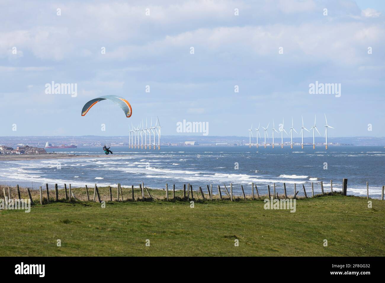 Parapente avec le parc à vent Teesside Offshore au-delà, Redcar, North Yorkshire, Royaume-Uni Banque D'Images