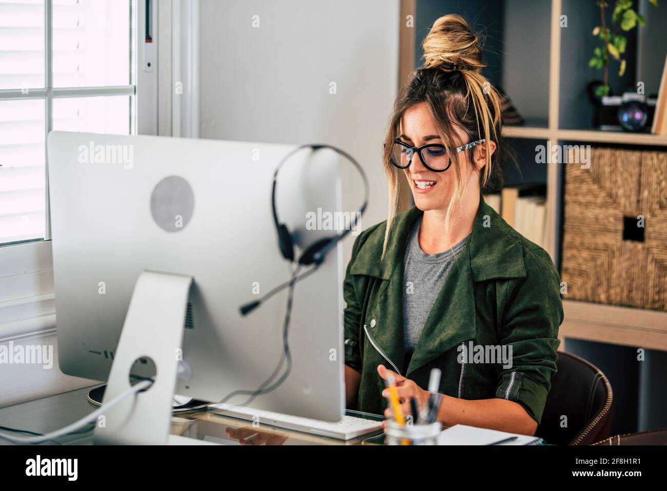 Bonne jeune femme adulte dans la vidéoconférence à la maison dans le travail intelligent, libre alternative au mode de vie de travail de bureau - joli les femmes reçoivent des nouvelles sur Banque D'Images