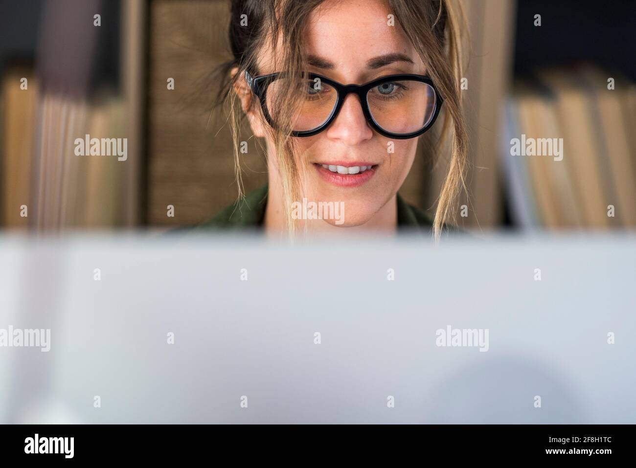 Tête de tir agréable bonne jeune femme freelance travaillant sur ordinateur à la maison. Femme d'affaires attrayante étudiant en ligne, en utilisant un logiciel d'ordinateur portable, Web surf Banque D'Images