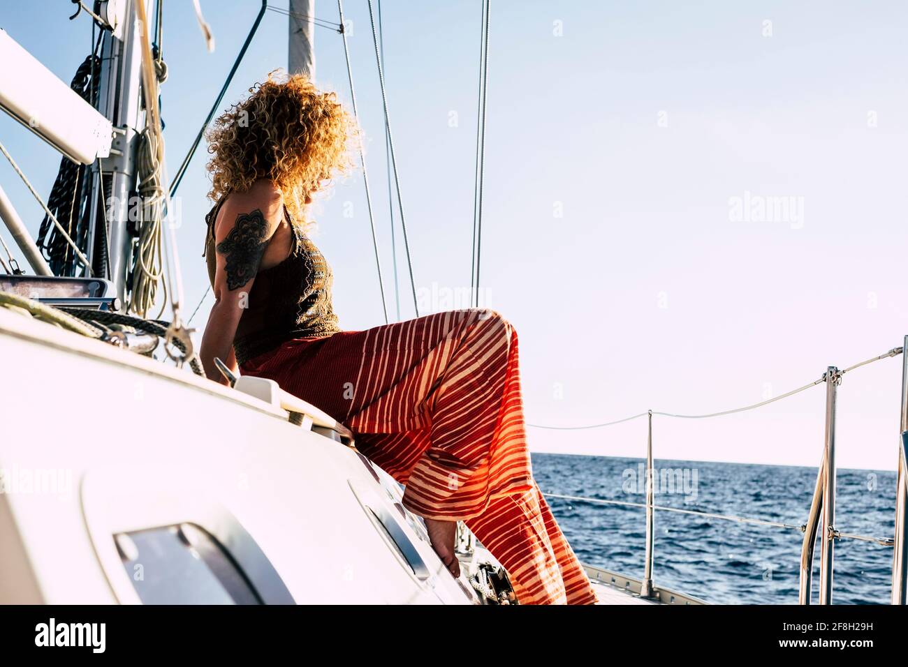 Une jeune femme se détend et fait une excursion en voilier vacances d'été - des femmes assises sur le yacht terrasse regardant l'horizon avec b Banque D'Images